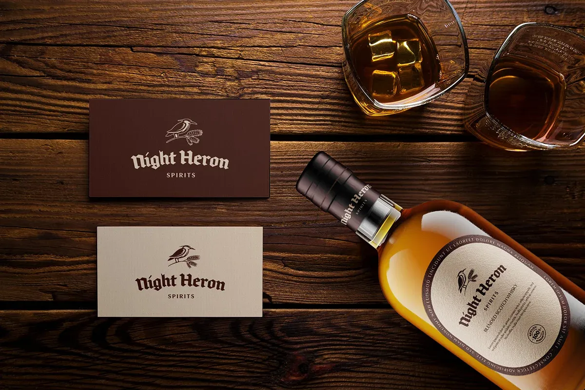 projekt logo widoczny na wizytówkach oraz projekt etykiety pokazany na butelce whisky